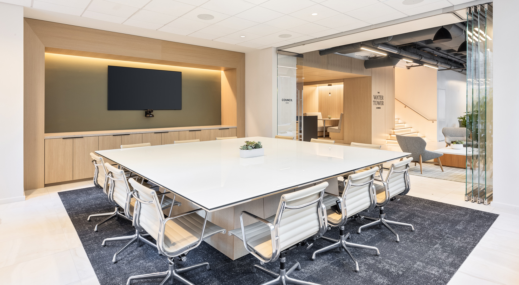 A luxury meeting room holding a large square conference table