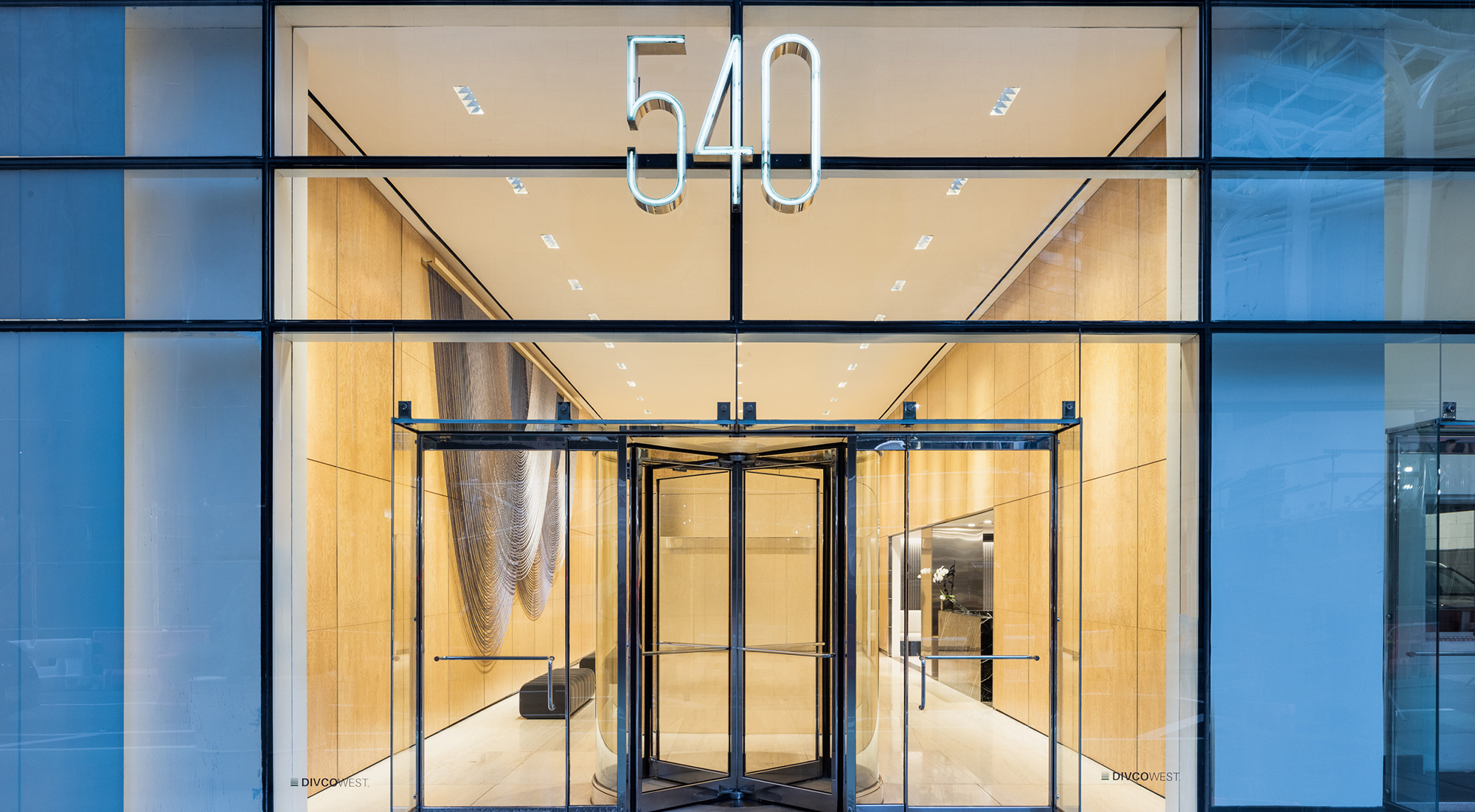 540 Madison building glass entrance with neon light address sign
