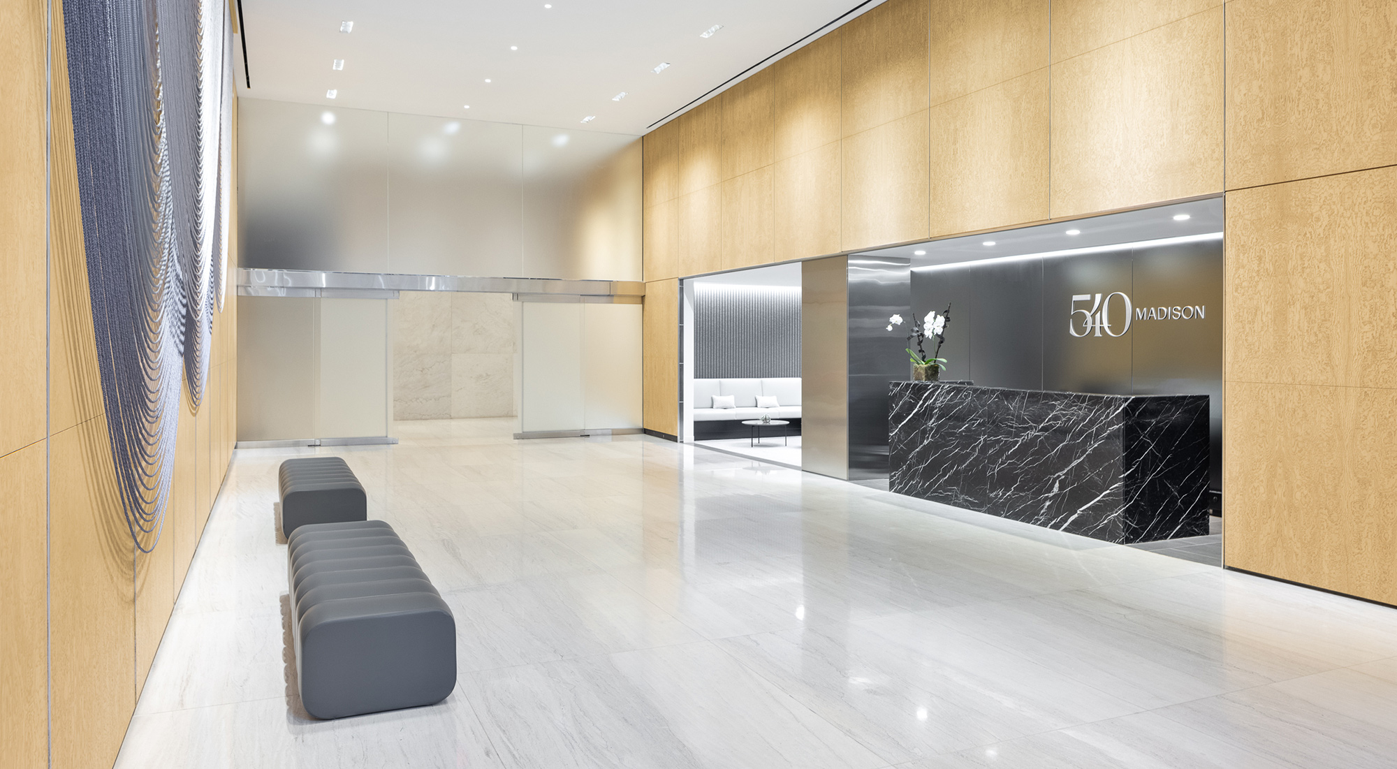 Highly modern lobby space and front desk with white marble floors